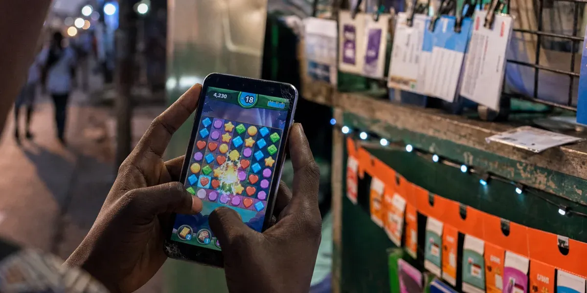 Carrier billing in emerging markets — playing a match-3 game at a prepaid recharge kiosk at dusk